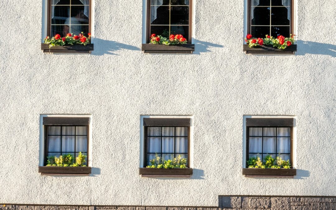 Gebäudereinigung in Ennigerloh - Weißes Haus mit Blumenkästen vor den Fenstern